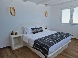 a white bedroom with a large bed and a window at Amerisa Suites & Villa in Fira
