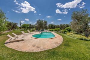 Una piscina en un patio con sillas alrededor. en Villa Le Majole by Perle di Puglia, en Manduria