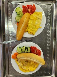 two plates of food with a hot dog and vegetables at Catba Papillon Garden Bungalows & Resort in Cat Ba