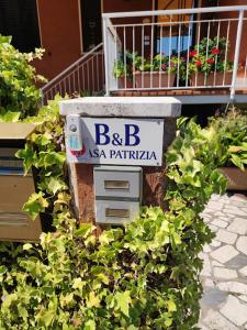 a stone box with a sign on top of plants at Casa Patrizia B&B cir in info in Sirmione