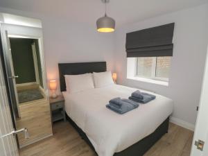 a bedroom with a bed with two towels on it at 1 Staveley Cottages in Weaverthorpe