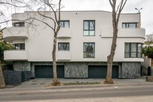 een wit gebouw met twee bomen ervoor bij Baltivia Haus I in Gdynia