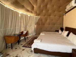 亞喀巴的住宿－Wadi Rum Marcanã camp，卧室配有一张床和一张桌子
