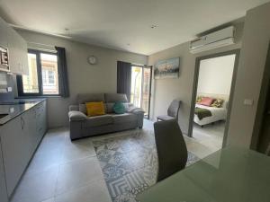 cocina y sala de estar con sofá y mesa en Eva Recommends Soho Alameda, en Sevilla