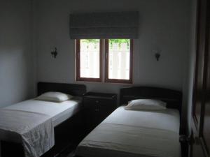 two beds in a room with a window at Baan Finland - 2 Bedroom apartment in Hua Hin