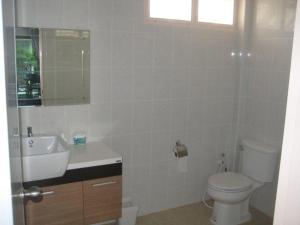 a white bathroom with a toilet and a sink at Baan Finland - 2 Bedroom apartment in Hua Hin