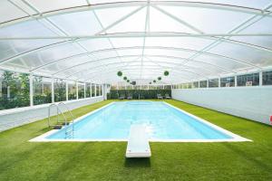 a large swimming pool with a glass roof at Spa home with pool sauna hottub & cocktail bar in Sheffield