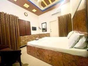 Rehaish Inn Model Colony في كراتشي: غرفة نوم بسرير كبير في غرفة