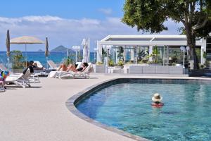 - une piscine avec une personne dans l'eau dans l'établissement Hôtel Restaurant Dolce Vita, à Ajaccio