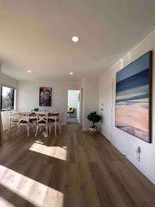 een woonkamer met een tafel en een groot schilderij aan de muur bij Family Perfect - Xmas bliss, secure yard, arcade in Rotorua