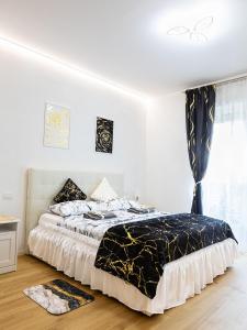 Schlafzimmer mit einem Bett mit einer schwarzen und weißen Bettdecke in der Unterkunft Angels apartment in Bari