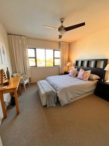 a bedroom with a large bed with pink pillows at 503 Hawaan View in Durban