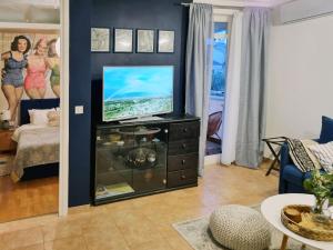 a living room with a flat screen tv on a dresser at Apartment Sol Dolcevita in Njivice