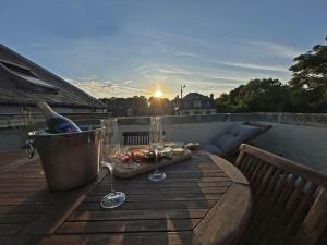 een tafel met wijnglazen en een fles op een balkon bij ROOFTOP - COSY FLAT Jacuzzi Privatif Centre Senlis in Senlis