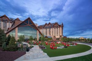 オーロラにあるGaylord Rockies Resort & Convention Centerの公園内の赤いテーブルと椅子が備わる大きな建物