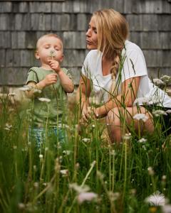 a woman and a baby sitting in the grass at Waldhütte Kosak in Trofaiach
