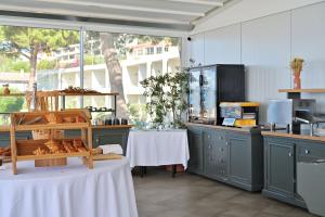a kitchen with a table and a counter with bread at Hôtel Restaurant Dolce Vita in Ajaccio