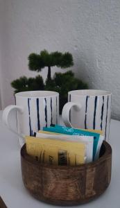 two coffee cups and a wooden bowl with books at Apartments and Rooms Batoš in Zavala