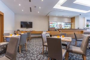 a restaurant with tables and chairs and a flat screen tv at Best Western Hotel President - Colosseo in Rome