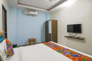 1 dormitorio con 1 cama y TV en la pared en FabHotel SM Palace, en Chinhat