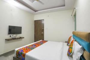 Un dormitorio con una cama con una manta de colores. en FabHotel SM Palace, en Chinhat