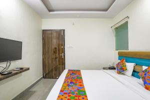 1 dormitorio con 1 cama con TV y 1 cama sidx sidx sidx sidx en FabHotel SM Palace, en Chinhat