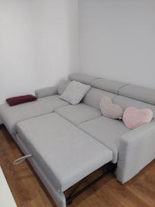 a couch with two pillows and two hearts on it at bel appart T2 confortable en plein coeur de Sigean in Sigean