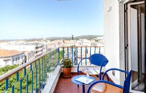 a balcony with two blue chairs and a view of a city at Loulé Old Town Apartment in Loulé