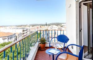 a balcony with two blue chairs and a view of a city at Elegant Apartment Overlooking Historic Loulé in Loulé