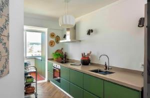 a kitchen with green cabinets and a sink at Elegant Apartment Overlooking Historic Loulé in Loulé