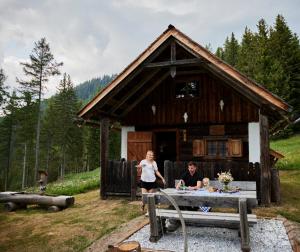 特罗法伊亚赫Waldhütte KOSAK - jetzt neu mit Bad & WC的站在小屋前的男人和女人