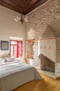 a bedroom with a large bed and a stone wall at FOS Hydra residence in Hydra