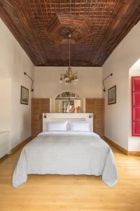 a bedroom with a large bed with a wooden ceiling at FOS Hydra residence in Hydra