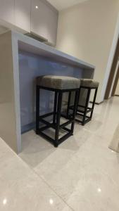 a kitchen with two bar stools in a room at GTC Posh Hideaway in Westlands in Nairobi
