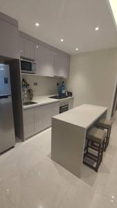 a white kitchen with a counter and chairs in it at GTC Posh Hideaway in Westlands in Nairobi