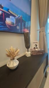 a black counter with a tv and a vase on it at GTC Posh Hideaway in Westlands in Nairobi