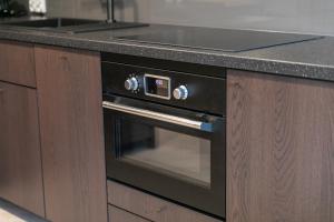 a black oven in a kitchen with a counter at VacationClub – Ogrody Pieniawskie Apartament 21 in Polanica-Zdrój