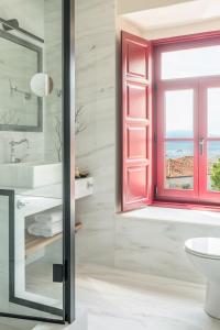 bagno con finestra rossa e lavandino di FOS Hydra residence a Hydra