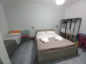 1 Schlafzimmer mit 2 Betten und 2 Stühlen in der Unterkunft B&B da Giovanna in Santa Maria del Cedro