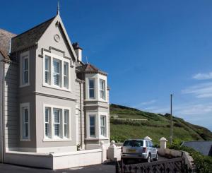 a white house with a car parked in front of it at Southcliff House in Portpatrick