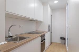 a kitchen with white cabinets and a sink at Stay In Sunset Campello in El Campello
