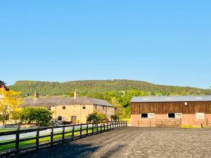 a farm with two barns and a fence at THE HAYLOFT CHESHIRE in Congleton