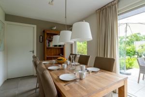 Un comedor con mesa y sillas de madera. en Landhuis Tempelierweg 23, en Den Burg