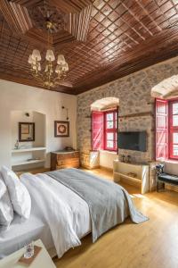 una camera da letto con un letto grande e una TV di FOS Hydra residence a Hydra