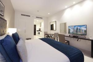 a bedroom with a king sized bed and a desk at SHH - Funished Studio with Balcony in Damac Celestia, Dubai South Near Expo in Dubai
