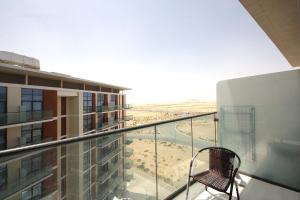 SHH - Funished Studio with Balcony in Damac Celestia, Dubai South Near Expo في دبي: كرسي على شرفة المبنى