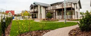 a house with a garden in front of it at Vila Nikolas in Druskininkai