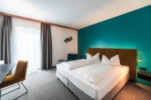 a bedroom with a large bed and a blue wall at Landhotel Prielbauer in Mondsee