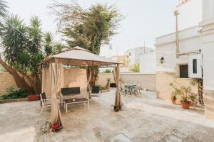 un patio con sombrilla, mesa y sillas en B&B Nuovo Reale - CENTRO STORICO, en Lecce