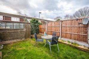 Elite 2 Bedroom House in Chadwell Heath/ Romford with Free Wifi and Parking upto 4 guests في Goodmayes: فناء مع طاولة وكراسي في الفناء
